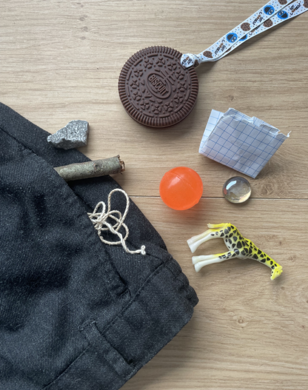 Biscuit chew necklace with school trousers and kids pocket contents