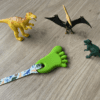 Green Foot Chew Necklace on Dinosaur lanyard with toy dinosaurs