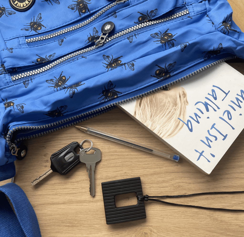 Black square chew necklace with handbag and contents