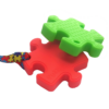 Red puzzle chew and green puzzle chew necklace in a stack