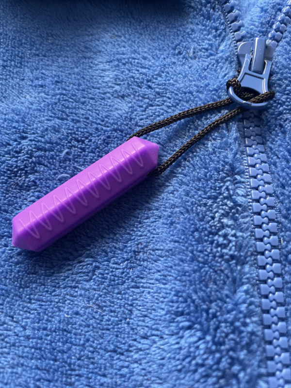 1 purple Zip Chew attached to a blue jacket