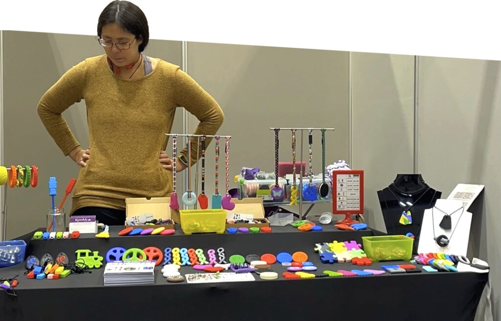 Exhibition table at conference showing chew necklace range