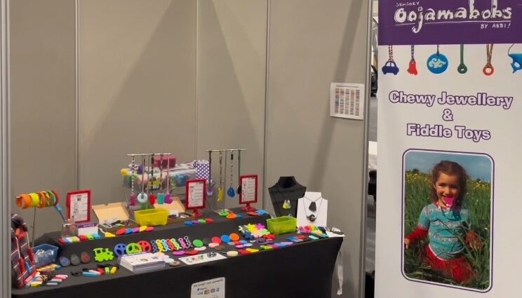 Exhibition table at conference showing chew necklace range