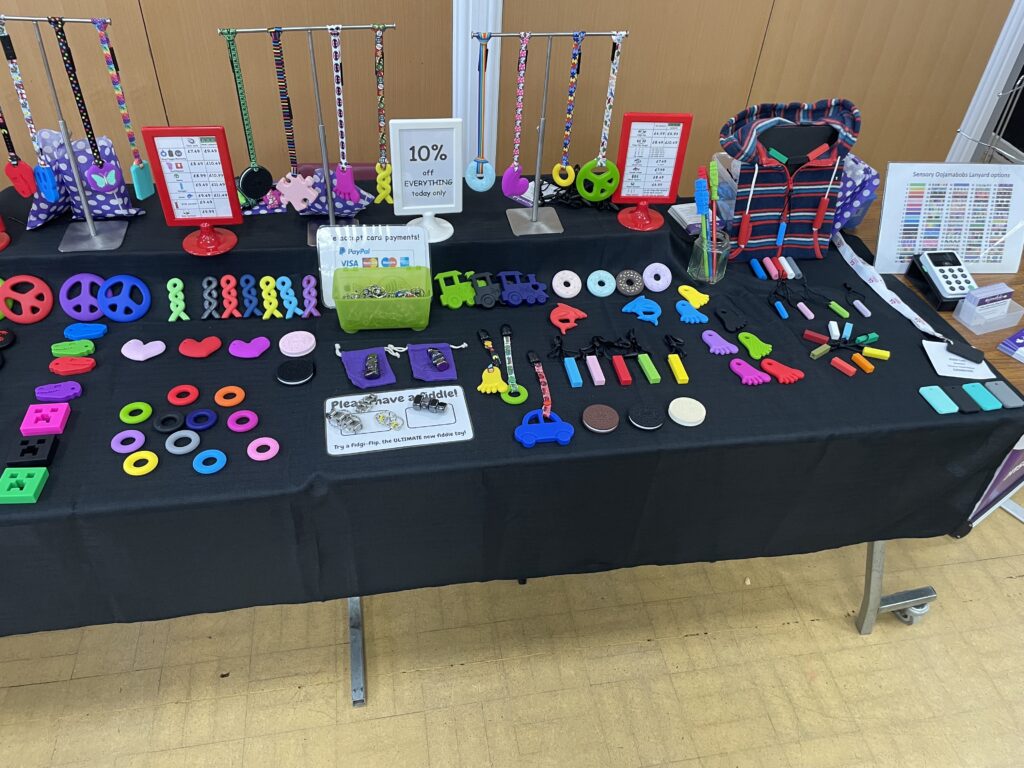 Exhibition table at conference showing chew necklace range