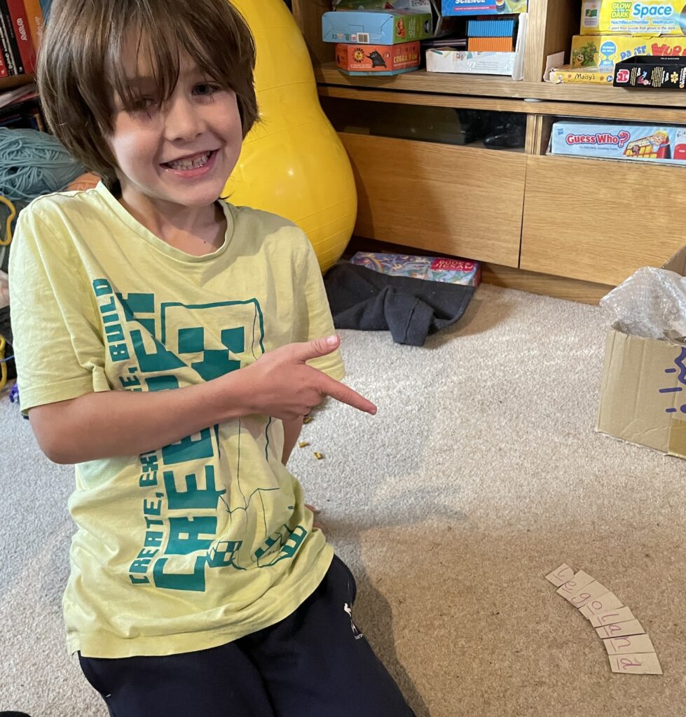 Smiling boy pointing at solved clue