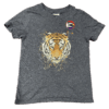 Pronoun pop badge with Pride flag backgrounds – she/her – from Sensory Oojamabobs on a navy child's t-shirt with a tiger on it