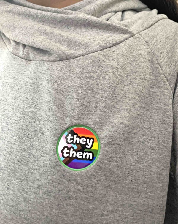 Pronoun pop badge with Pride flag backgrounds – they/them – from Sensory Oojamabobs
